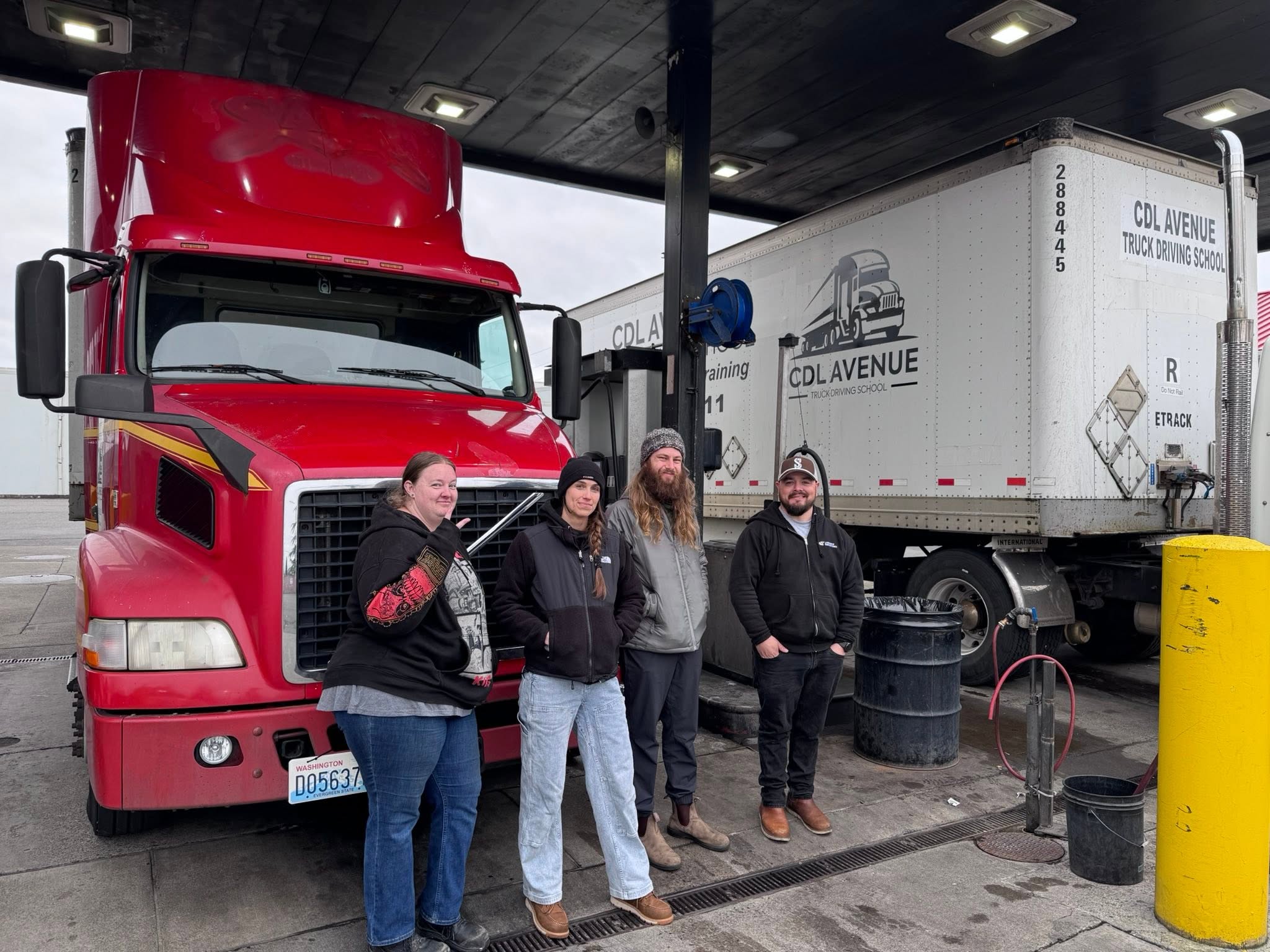 Students posing with CDL Avenue trucks