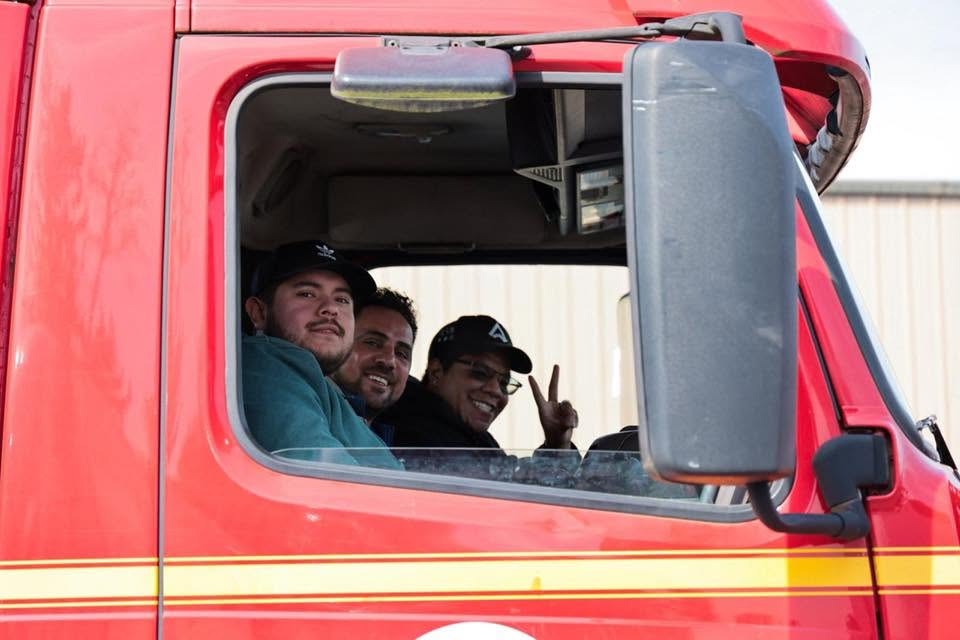 Students smiling from the cab of a truck